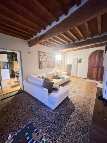 sala de estar con sofá blanco y TV en Villa Rosa, en Calci