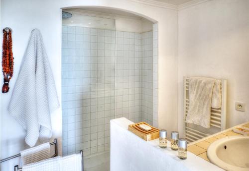 ein weißes Bad mit einer Dusche und einem Waschbecken in der Unterkunft Les Bastides 3028 in Grimaud