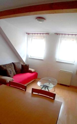 a living room with a red couch and a glass table at Ubytování Sušice in Sušice
