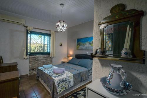 een slaapkamer met een bed en een kroonluchter bij Nerotrivia Villa - Ocean Panorama and Lush Gardens in Nerotriviá
