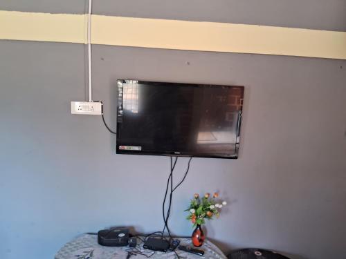 a flat screen tv hanging on a wall at Royal homes a5 in Kushālnagar