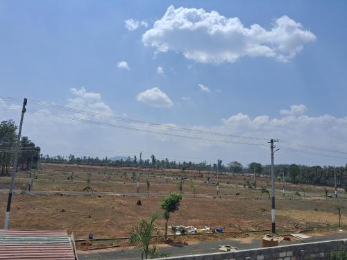 a large field with trees in a field at Royal homes a5 in Kushālnagar