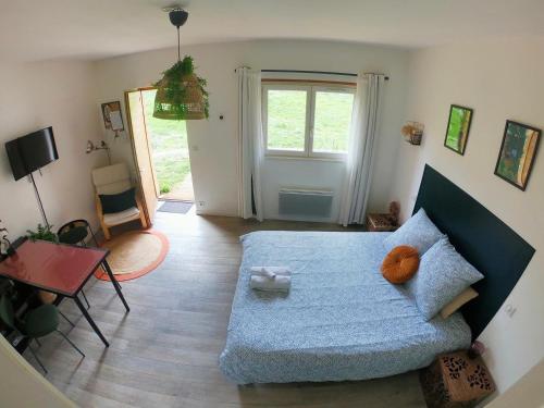 1 dormitorio con 1 cama con manta azul en EVASION NATURE ET CONVIVIALITÉ, en Sourcieux-les-Mines