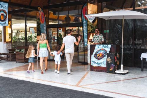 a family walking down a street outside a store at Magic Tropical Splash in Cala de Finestrat