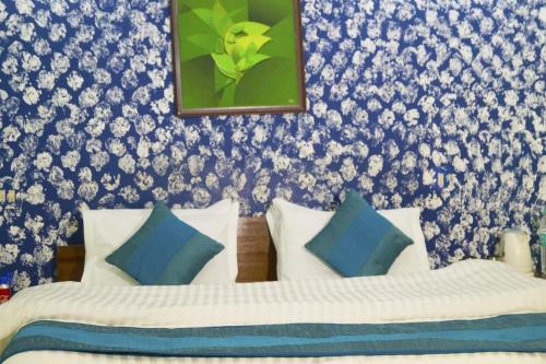 a bedroom with two beds with blue and white pillows at Hotel HRS - New Delhi Railway Station in New Delhi