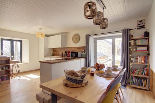 une cuisine avec une table en bois et une salle à manger dans l'établissement L'orée du Mézenc et son bain nordique privatif, à Saint-Front