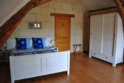 une chambre avec un lit blanc et un mur en pierre dans l'établissement Le Tulipier de Virginie, à Noyers-sur-Cher