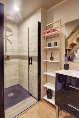 une salle de bain avec douche et porte vitrée dans l'établissement L'orée du Mézenc et son bain nordique privatif, à Saint-Front