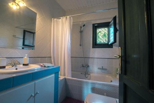 y baño con lavabo, bañera y aseo. en Nerotrivia Villa - Ocean Panorama and Lush Gardens, en Nerotriviá