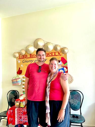 a man and a woman standing in front of a table at Cherry Homestay - Hoàng Đế motel in Chau Doc