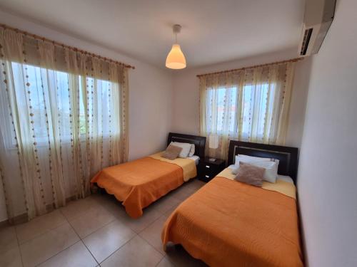 2 Betten in einem Zimmer mit Fenstern in der Unterkunft Apartment Helena in Paralimni