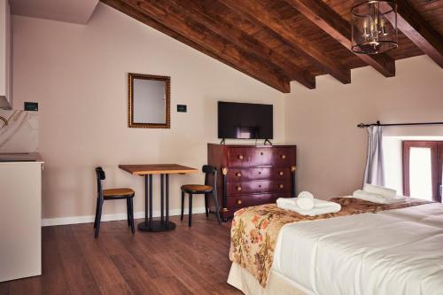 Schlafzimmer mit einem Bett, einem Tisch und einem TV in der Unterkunft Casa Palacio Reina de Tardajos in Vinuesa