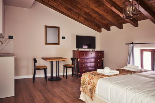 a bedroom with a bed and a table and a television at Casa Palacio Reina de Tardajos in Vinuesa