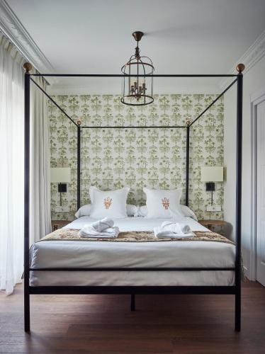 a bedroom with a canopy bed with a chandelier at Casa Palacio Reina de Tardajos in Vinuesa