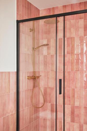 a shower in a bathroom with pink tiles at Casa Palacio Reina de Tardajos in Vinuesa