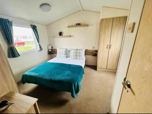 ein kleines Schlafzimmer mit einem Bett und einem Fenster in der Unterkunft The salsa golden gate towyn in Kinmel Bay