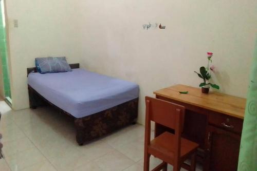 Habitación pequeña con cama y escritorio. en SPOT ON 93851 Fermansio Homestay 1, en Medan