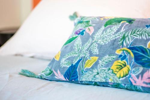 - un oreiller sur le lit avec un motif floral dans l'établissement Rêve - Appartement Terrasse Vue Mer, à Concarneau