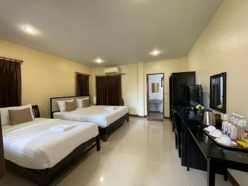 a hotel room with two beds and a flat screen tv at Pak Ping Rim Khong in Chiang Saen