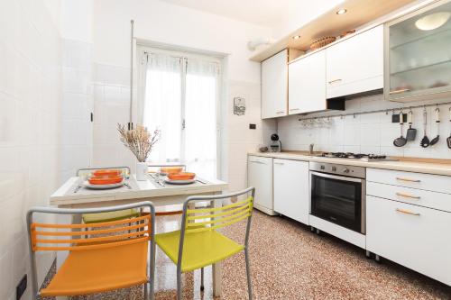 una cucina con armadi bianchi e sedie gialle di 9min CENTRO e STAZIONE FERROVIARIA a Genova