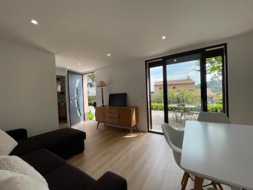 un salon avec un canapé, une table et une télévision dans l'établissement La carolienne, à Vallauris