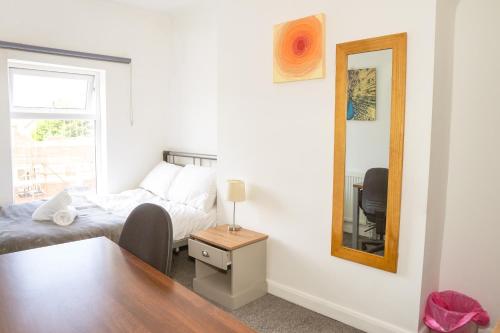 a small bedroom with a bed and a mirror at Blue Nile Apartment - Liverpool in Liverpool