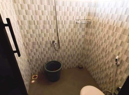 a bathroom with a bucket in the corner of a shower at SPOT ON 93880 Guest House Bu Iin Syariah in Sidoarjo