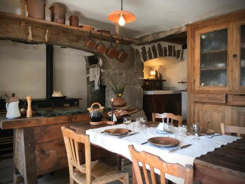 une cuisine avec une table et un chiffon de table blanc dans l'établissement Chambres et Tables d'hôtes - Les Ateliers de Pontajou - Pèlerin navette gratuite à Saugues, à Venteuges