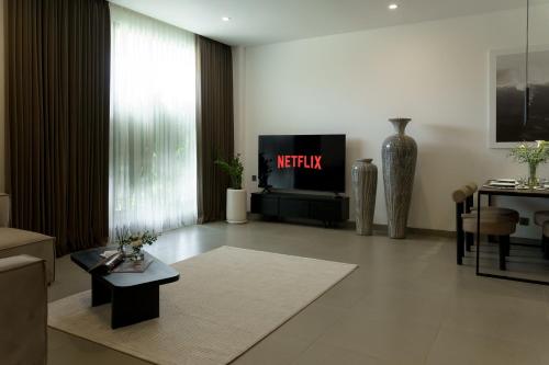 uma sala de estar com uma televisão e uma mesa em Sunny Aparts 1 em Canggu