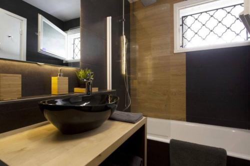 ein Bad mit einem schwarzen Waschbecken und einem Fenster in der Unterkunft Le Vauban avec les cles de Luz in Saint-Jean-de-Luz