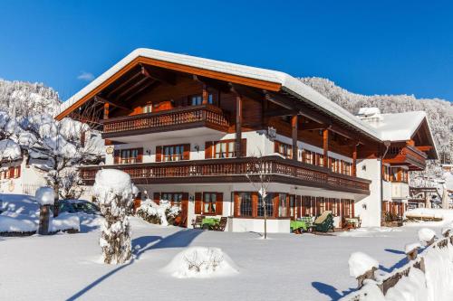 a large building in the snow with snow covered trees at Zum Eichhof in Reit im Winkl