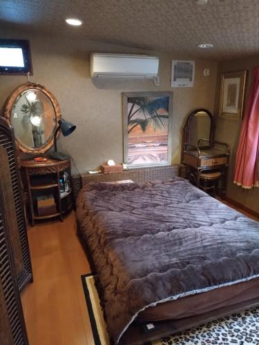 a bedroom with a large bed and a table and a window at Stage YOU in Tokyo