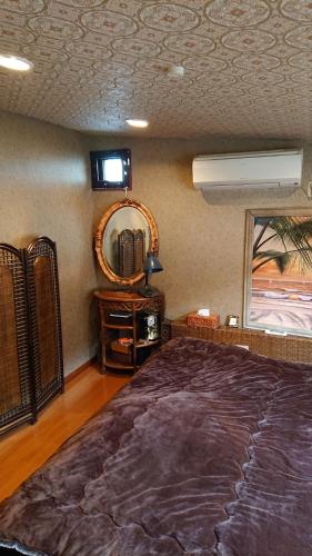 a bedroom with a large bed and a mirror at Stage YOU in Tokyo
