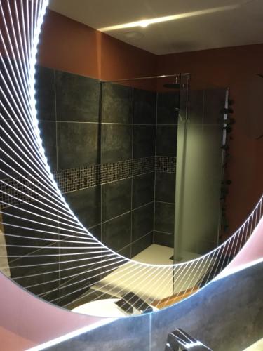 y baño con espejo circular y ducha. en Lov'Infini, en Mers-les-Bains
