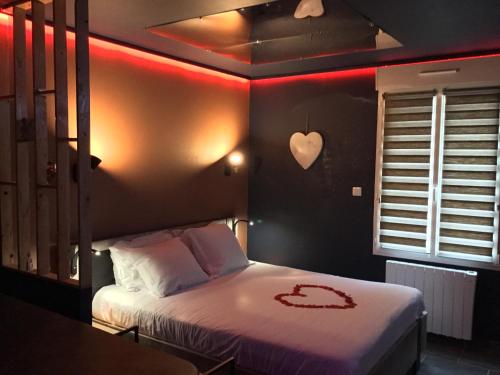 een slaapkamer met een bed met een hart aan de muur bij Lov'Infini in Mers-les-Bains