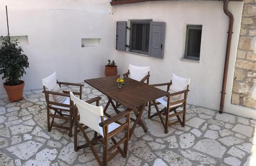 a wooden table and chairs on a patio at Ferienhaus Triandafilo in Pythagoreio