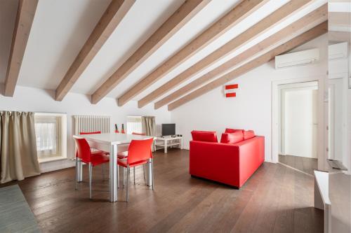 un soggiorno con tavolo e sedie rosse di Villa Aranci Downtown a Riva del Garda