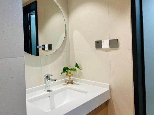 uma casa de banho com um lavatório branco e um espelho. em Pikkie Designer's Stylish Three Bed Room Apartmemt em Zhangjiajie