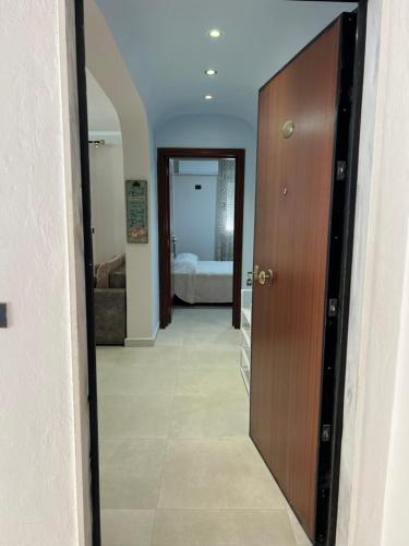 einen Flur mit Tür und ein Zimmer mit Bett in der Unterkunft SKetch Apartments 2 in Durrës