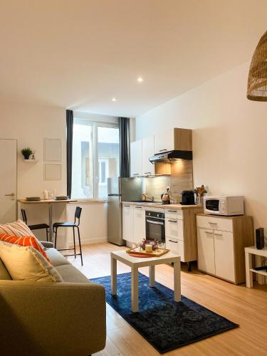 une cuisine et un salon avec un canapé et une table dans l'établissement Studio cosy Eglise Notre-Dame-des-Calades, à Villefranche-sur-Saône