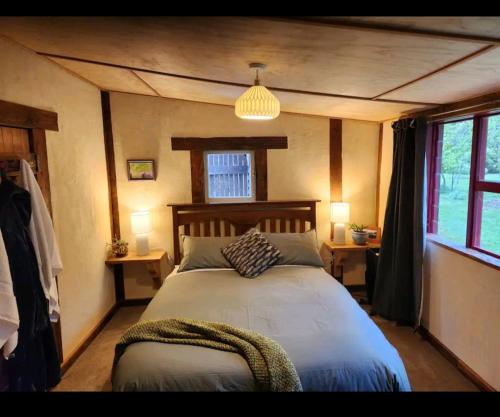 ein Schlafzimmer mit einem großen Bett in einem Zimmer in der Unterkunft Danseys Pass Lavender Farm in Tokarahi