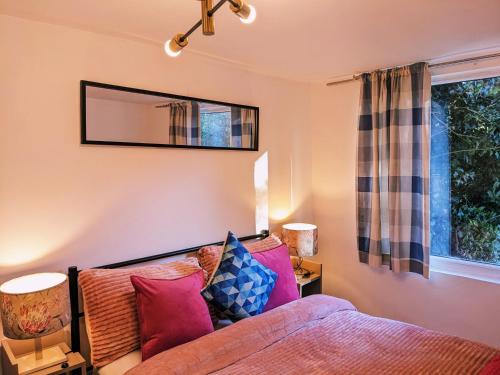 a bedroom with a bed and a mirror on the wall at Small apartment in the heart of Selsdon! in Addington