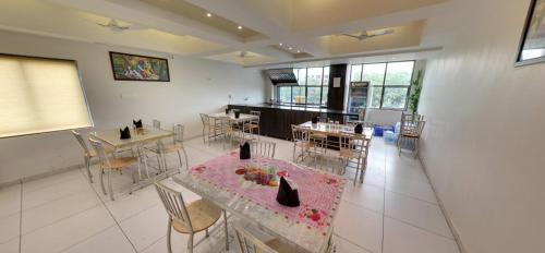a large room with tables and chairs and a kitchen at Hotel Best Velly in Gandhinagar