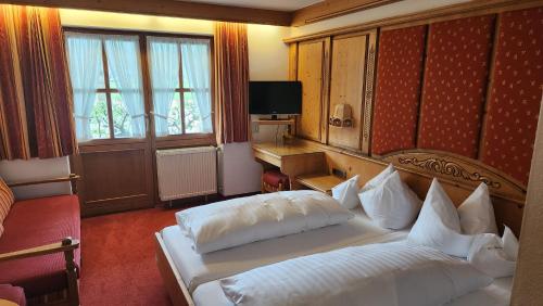 a hotel room with a bed and a television at Zum Eichhof in Reit im Winkl