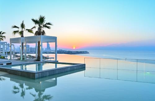 an infinity pool with a view of the ocean at Onyx Rotana in Manama
