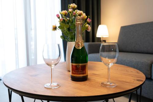 a bottle of champagne and two glasses on a table at Novaio City Apartments in Ioannina