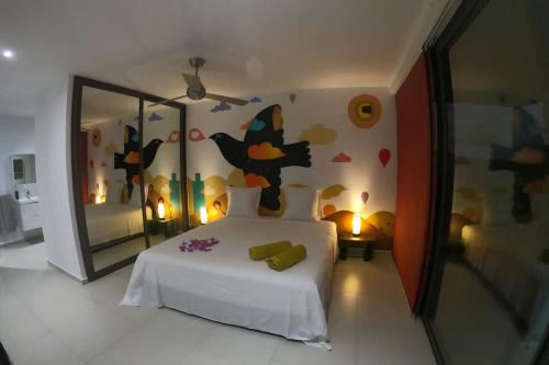 a bedroom with a bed and a wall with butterflies at La Canopée vue sur mer in Nosy Be