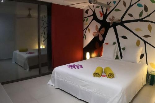 a bedroom with a bed with two yellow shoes on it at La Canopée vue sur mer in Nosy Be