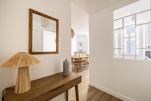 Cette chambre comprend un miroir et une table avec une lampe. dans l'établissement Beautiful 1BR, heart of Suquet-Cannes - 5min beach, à Cannes