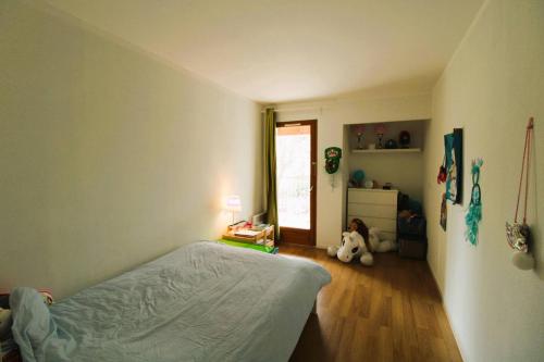 1 dormitorio con 1 cama y 1 habitación con ventana en CARBAU Maisonnette pour 8 personnes dans une résidence privée avec piscine à Carqueiranne, en Carqueiranne